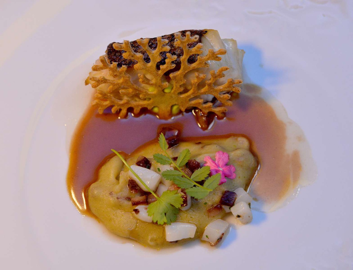 Peixe da costa local com choco, migas, enchidos bolota e coentros.&nbsp;