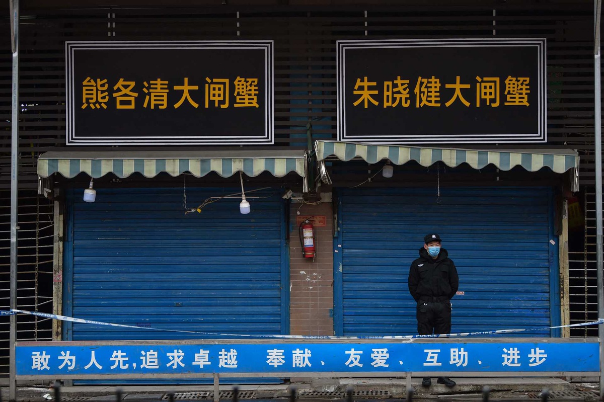 Um segurança guarda a entrada para o Mercado de Huanan, o epicentro da pandemia de covid-19, a 24 de Janeiro de 2020.