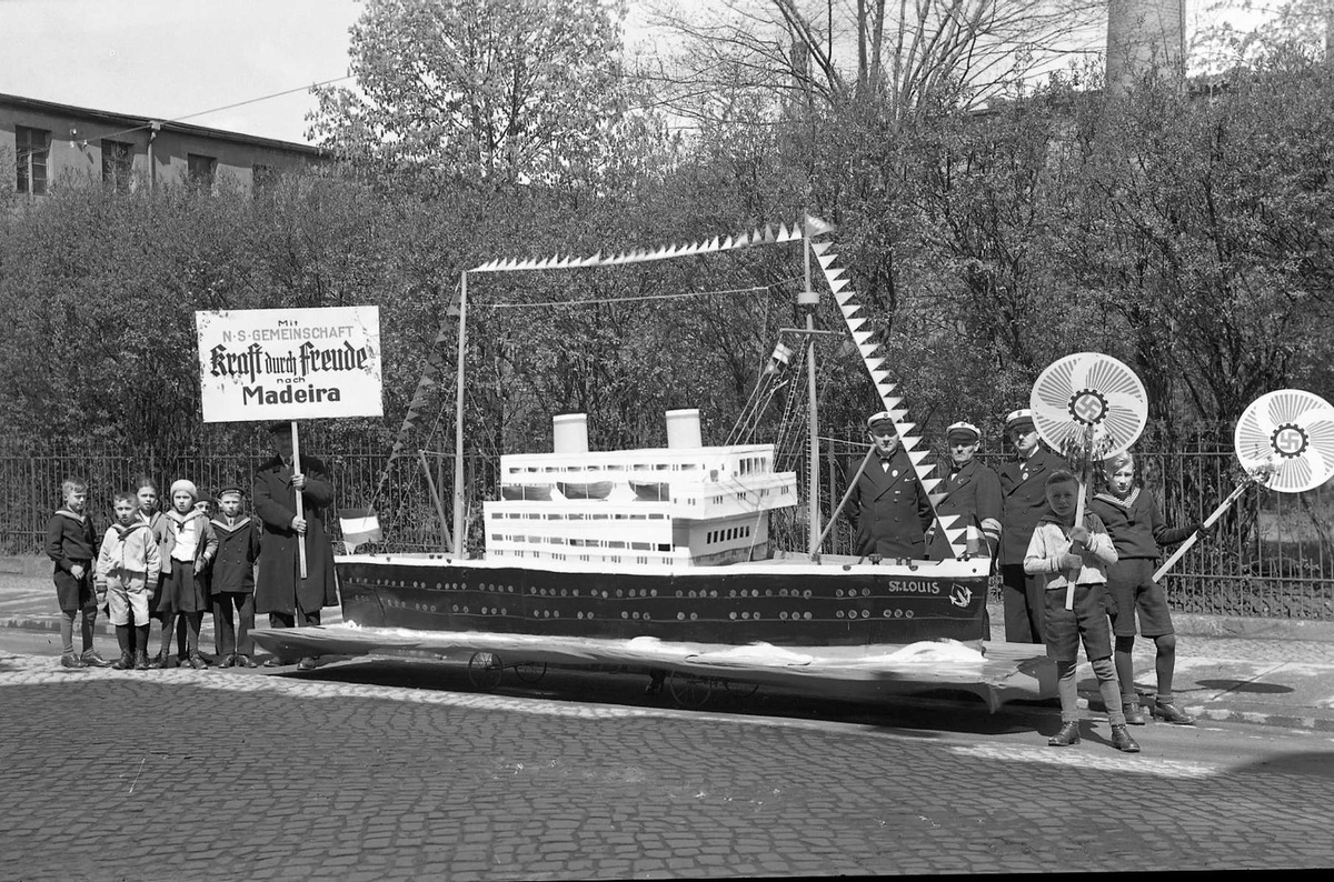 Desfile festivo do 1.º de Maio de 1935, Dia do Trabalhador, em Rosswein, Alemanha, com propaganda da organização nazi "Força pela Alegria" para viagens à Madeira. Note-se a maquete do navio 'St. Louis'. FOTO DEUTSCHE FOTOTHEK
