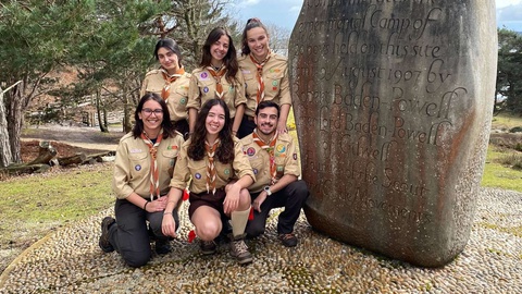 Escoteiros junto&nbsp; à&nbsp;pedra comemorativa do primeiro acampamento, no local onde se realizou