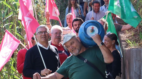 A imagem da campanha: o candidato da CDU Pedro Carvalho a carregar uma garrafa de gás por um beco das zonas altas.