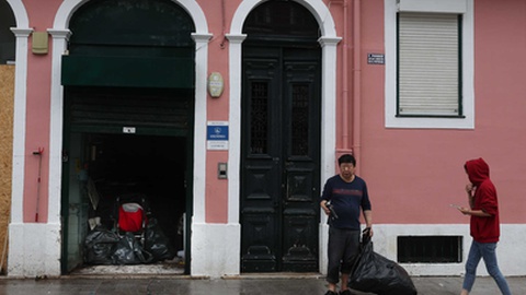 Comerciantes retiram mercadoria danificada do interior de uma loja em Algés, depois das inundações registadas a 13 de Dezembro devido ao mau tempo.