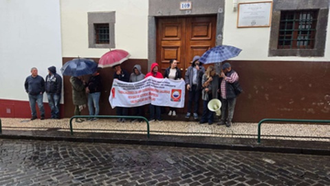 De um lado e do outro da rua, os trabalhadores foram-se abrigando para escapar da chuva.