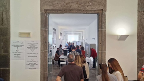 Os eleitores consultam os cadernos eleitorais afixados à entrada para identificar a sua mesa de voto.