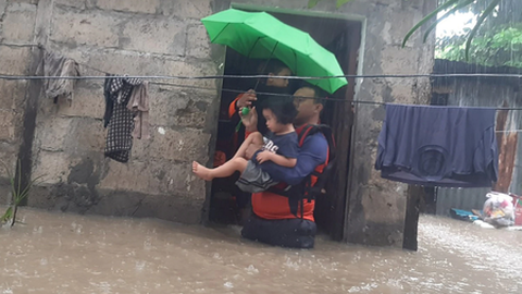 Socorristas a evacuar civis numa das áreas inundadas em Ozamiz, Filipinas, a 25 de Dezembro de 2022