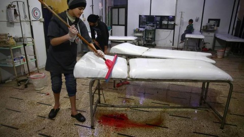 Empregada da limpeza tenta ‘apagar’ vestígios do massacre em Damasco, na Síria. FOTO Reuters
