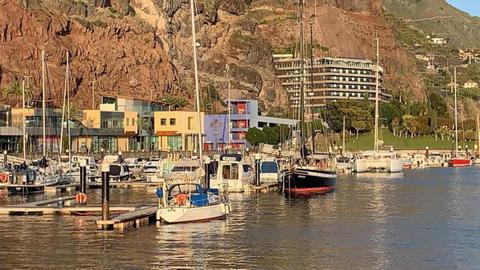 O pequeno veleiro branco está num pontão, isolado das restantes embarcações. Foto e Vídeo Vitor Hugo