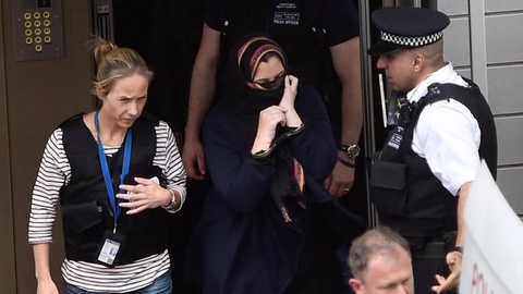 Uma mulher, algemada, é levada sob detenção pela polícia britânica. Foto Hannah McKay/Reuters