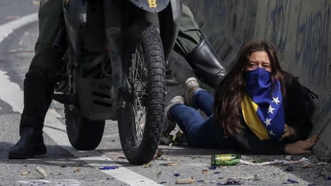 Manifestante é detida pela GNB, polícia nacional, enquanto participava nos protestos contra Maduro.   Foto EPA/Miguel Gutierrez