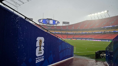 Adeptos abrigam-se do mau tempo antes do jogo entre Tunísia e Países Baixos.