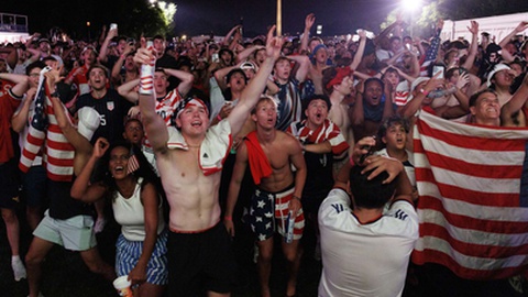 Adepto dos Estados Unidos celebra um golo no ecrã gigante da Fan Zone em Washington.