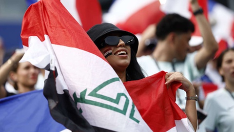 Adepto do Iraque segura a bandeira nacional antes do jogo frente à França no Mundial 2026.